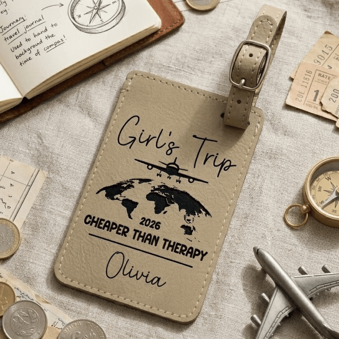 Beige luggage tag with travel-themed text and graphics on a surface with travel items.