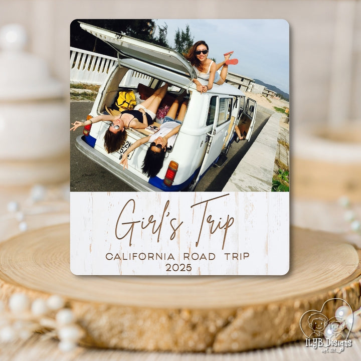 Travel photo gift with a photo of people in a van and 'Girl's Trip California Road Trip 2025' text on a wooden surface.