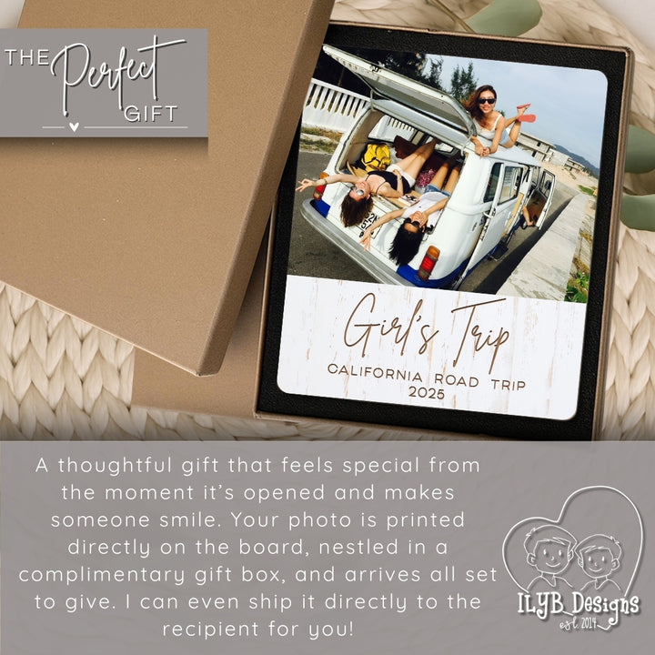 Personalized photo board with 'Girl's Trip' text, wrapped in a brown box, on a textured surface.