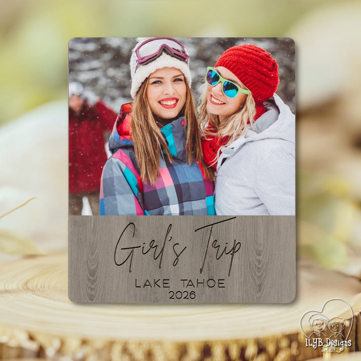 Personalized photo plaque with two people and 'Girl's Trip Lake Tahoe 2026' text on a wooden surface.