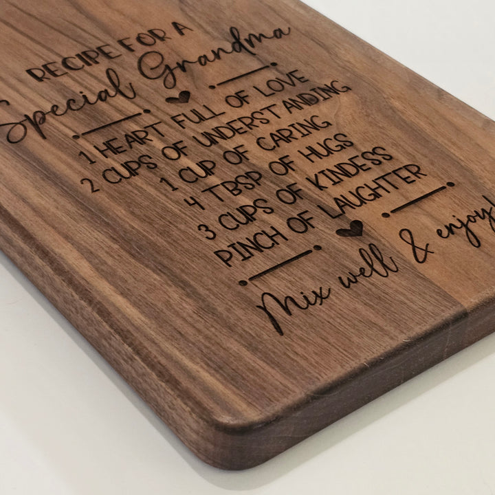 A rectangular wooden cutting board with rounded corners, featuring an engraved recipe for &