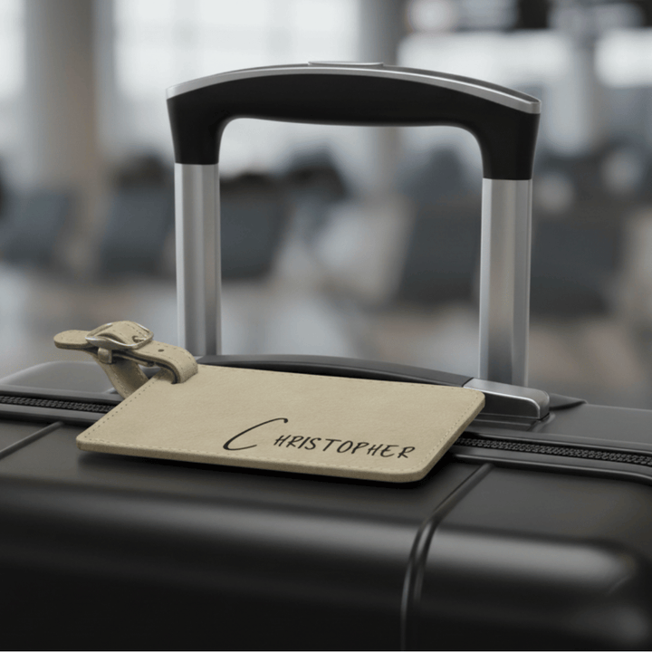 Black suitcase with a name tag labeled 'Christopher' in an airport setting
