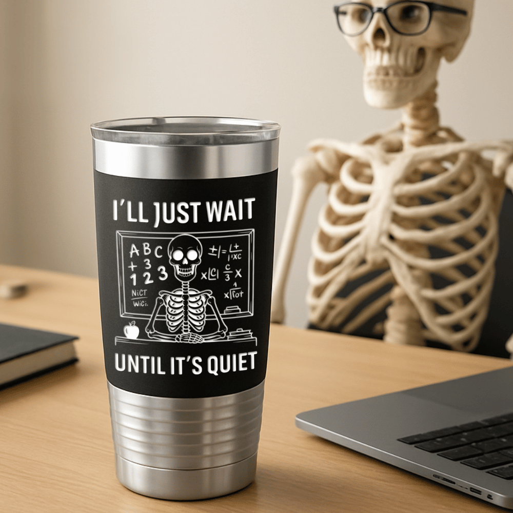 Tumbler with skeleton design and text that says 'I'll just wait until it's quiet' engraved in white sitting on a desk with a skeleton in the background