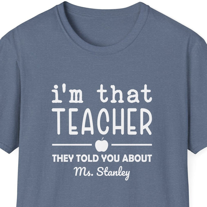 Blue t-shirt with white graphic that says 'i'm that teacher they told you about' and text on a white background
