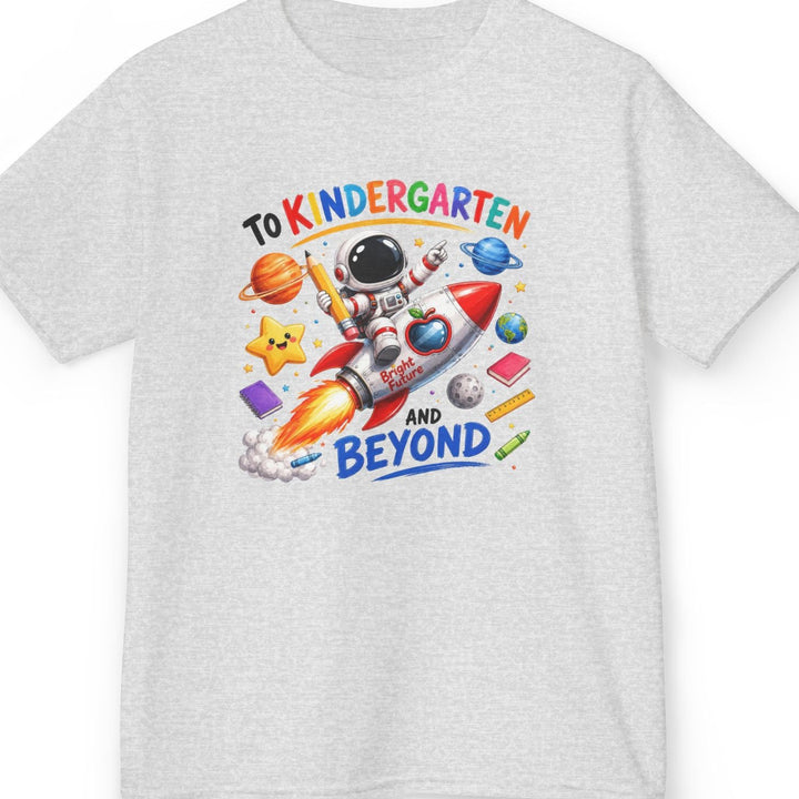 A light heather ash gray short-sleeve t-shirt with a colorful graphic on the chest featuring an astronaut, a rocket ship, planets, and the text 'TO KINDERGARTEN AND BEYOND'.