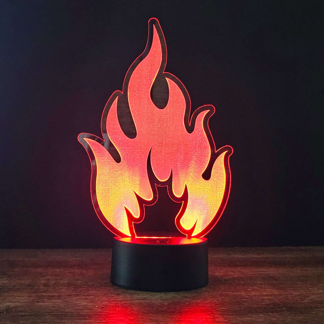 Flame-shaped night light on a wooden surface with a dark background