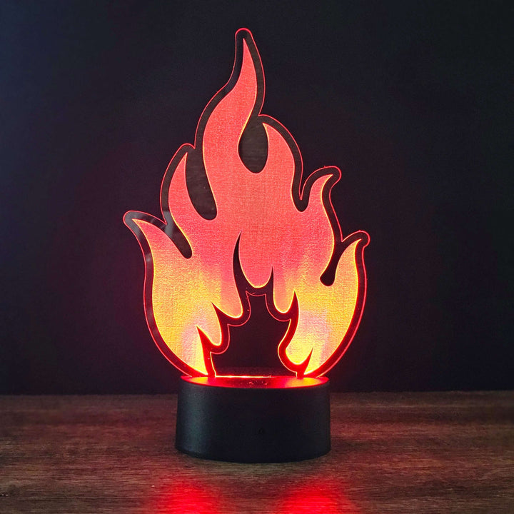 Flame-shaped night light on a wooden surface with a dark background