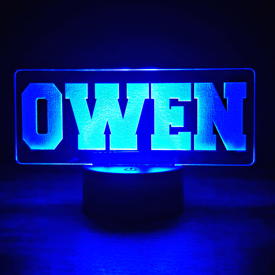 LED night light with 'OWEN' text engraved in acrylic in blue on a dark background