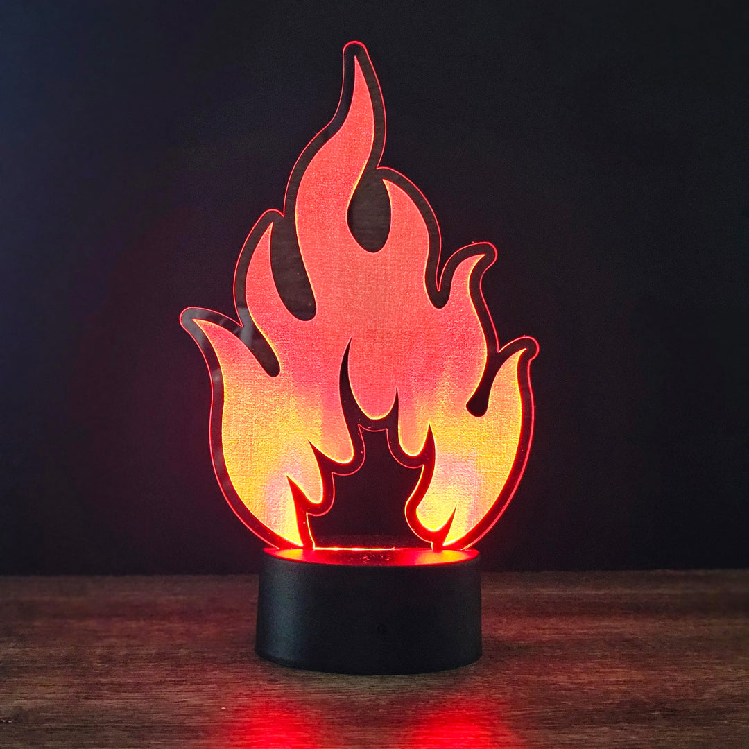 Flame-shaped night light on a wooden surface with a dark background