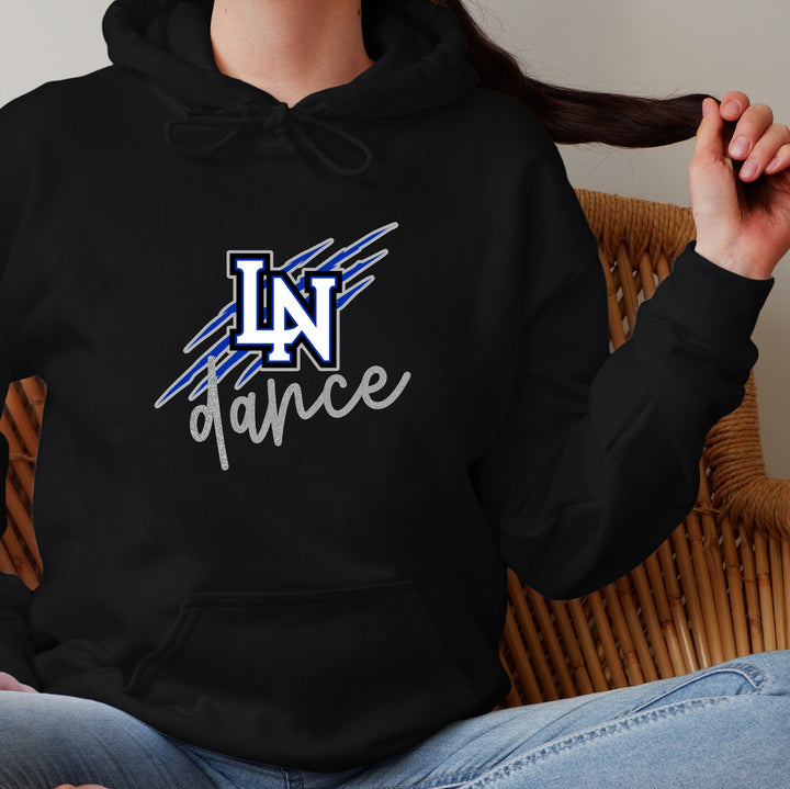 Girl wearing a black hoodie with blue, gray, and white 'LN dance' logo with 'dance' in glitter silver. Logo has wildcat scratch marks behind it.