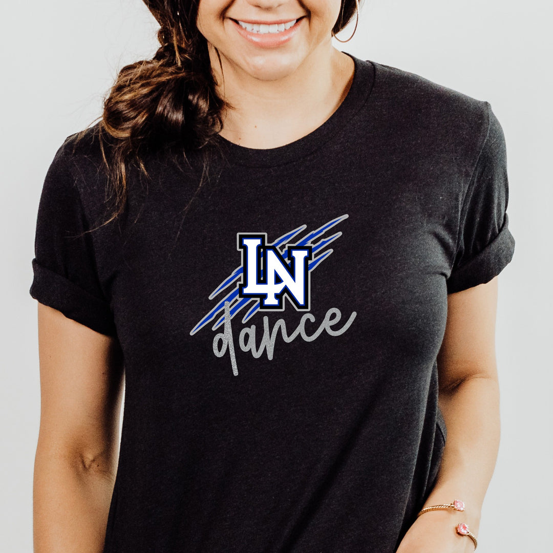 Person wearing a black t-shirt with blue, gray, and white 'LN dance' logo with 'dance' in glitter silver. Logo has wildcat scratch marks behind it.