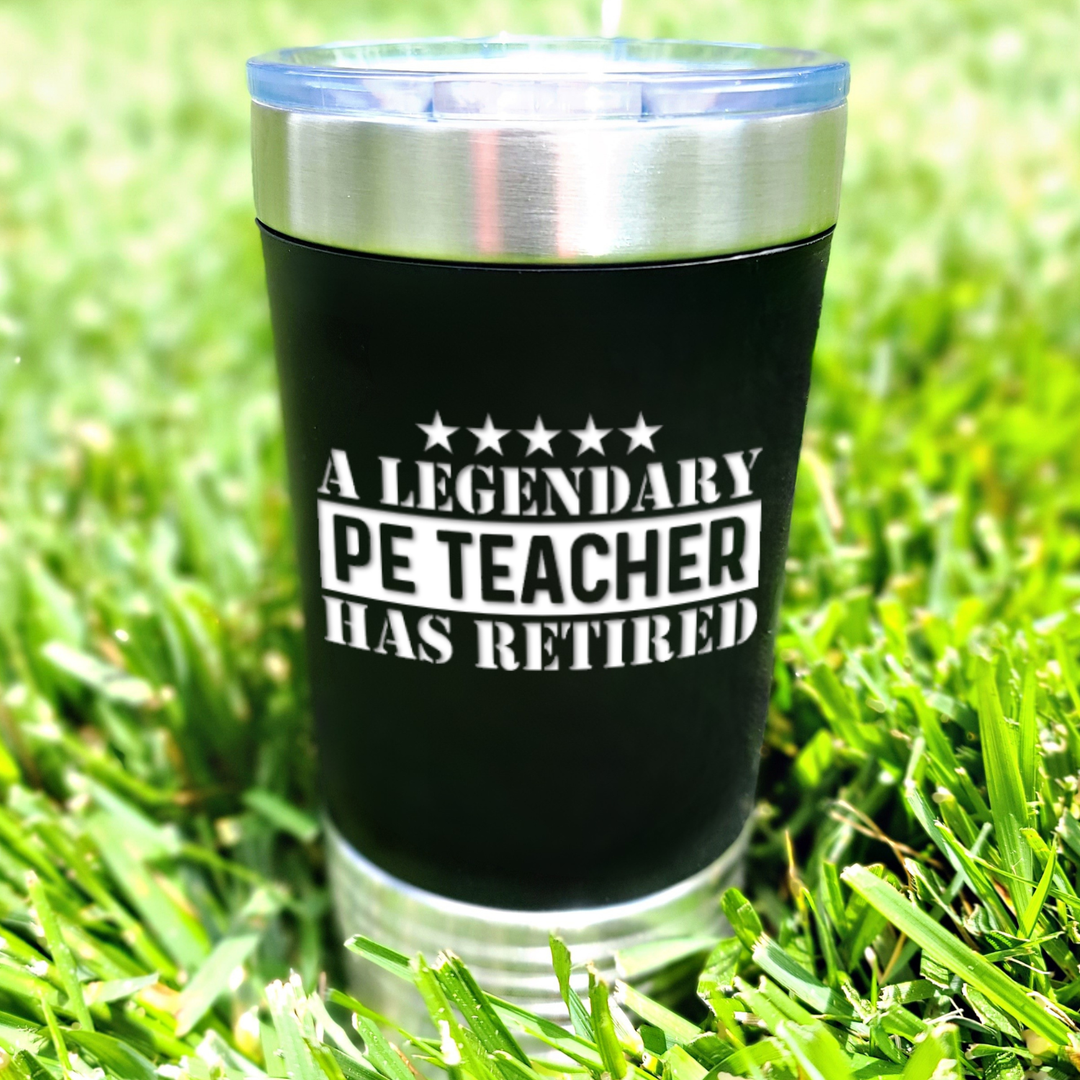 black Polar Camel 20oz tumbler sitting in green grass with the design engraved in white that says 'a legendary PE teacher has retired'