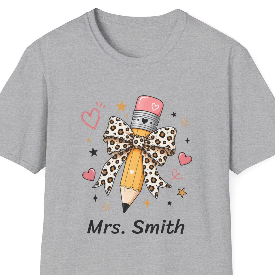 A light gray short-sleeve crewneck t-shirt featuring a graphic of a pencil dressed in a leopard-print bow and hat, with the text 'Mrs. Smith' printed below.