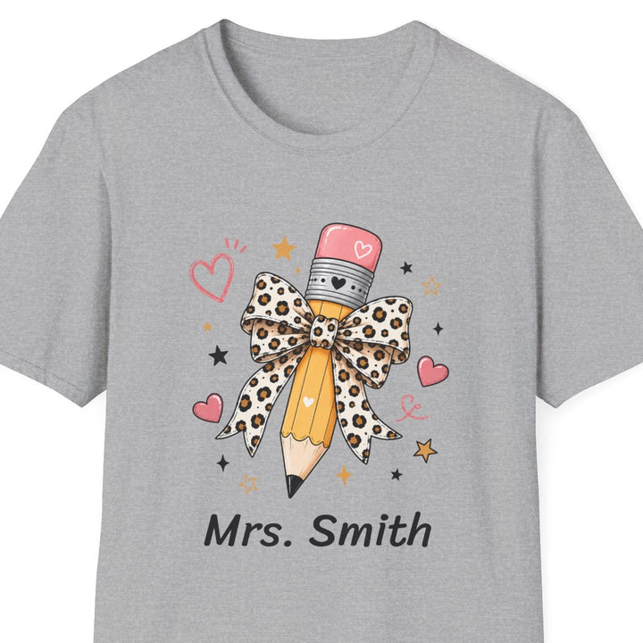 A light gray short-sleeve crewneck t-shirt featuring a graphic of a pencil dressed in a leopard-print bow and hat, with the text 'Mrs. Smith' printed below.