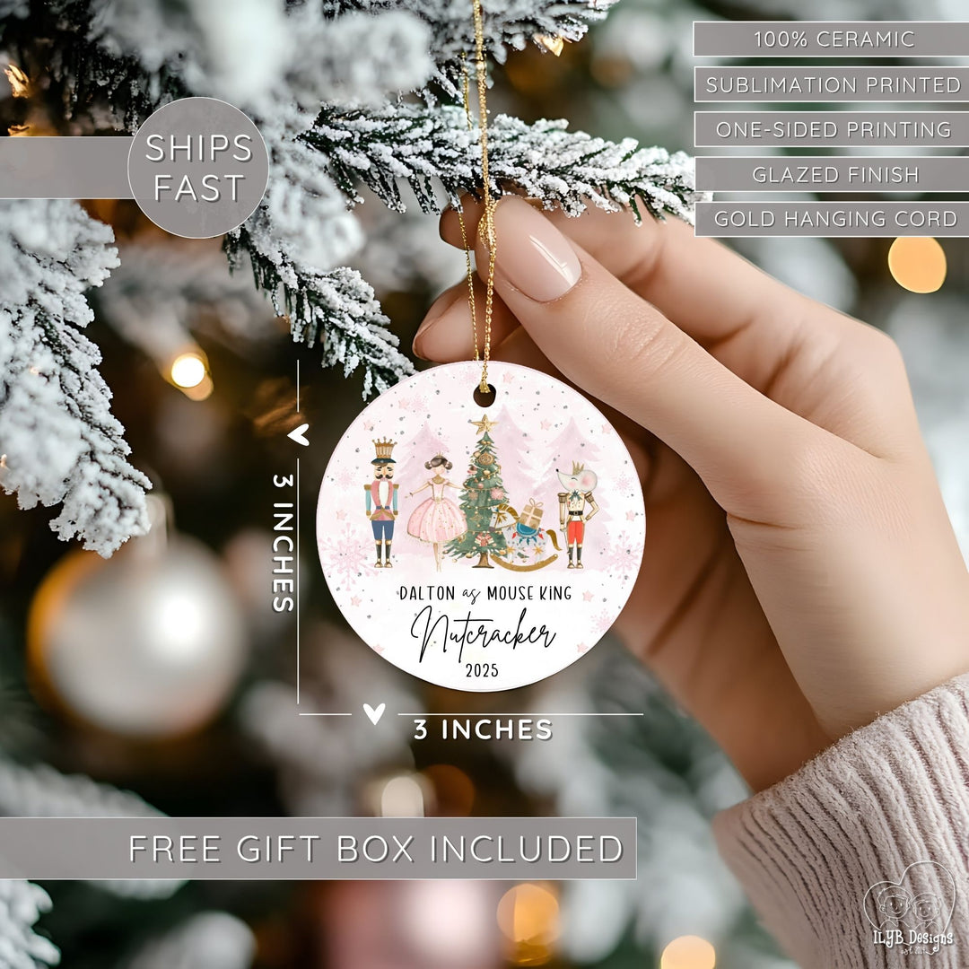 Hand hanging Nutcracker ballet ornament on a Christmas tree and showing dimensions of the Christmas ornament in perspective next to the hand. Ornament dimensions are 3 inches x 3 inches. Other features are highlighted: 100% ceramic, sublimation printing, one-sided print, glazed finish, gold hanging cord, free gift box included, ships fast.
