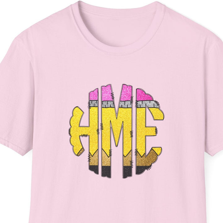 A light pink short-sleeve crewneck t-shirt featuring a graphic on the chest with the letters 'HME' in yellow, stylized as pencils.