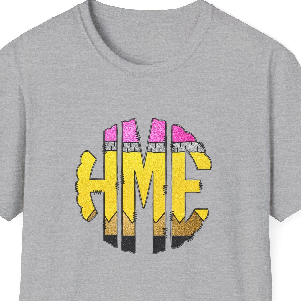 A heather gray short-sleeve t-shirt with a graphic on the chest featuring the letters 'HME' in yellow with pink and black striped details resembling pencils, shown on a plain white background.