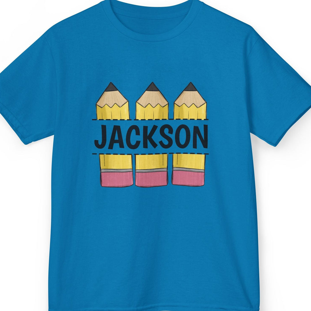 A bright blue short-sleeve t-shirt with a custom graphic on the chest. The graphic features three yellow and pink pencils stacked vertically, with the name 'JACKSON' printed in black across the middle.