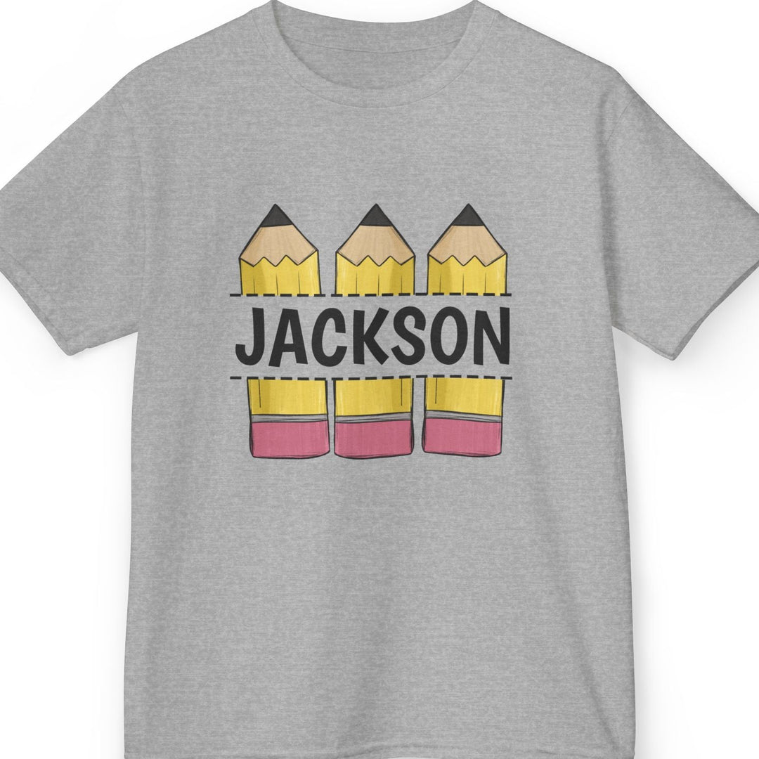 A heather gray short-sleeve t-shirt with a custom graphic print featuring three yellow pencils with pink erasers and the name 'JACKSON' printed across them in black block letters.