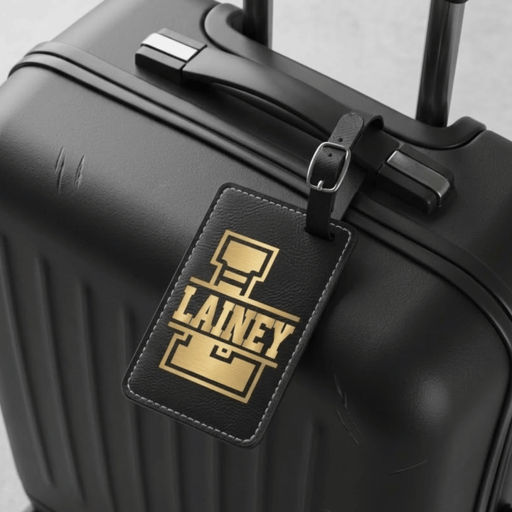 Black suitcase with a gold Lainey monogram engraved on luggage tag.