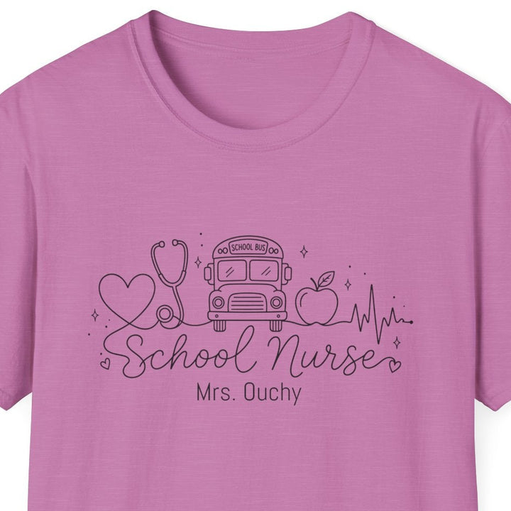 A pink short-sleeve crewneck t-shirt with a dark purple graphic on the chest featuring school nurse line drawn icons and the text 'School Nurse Mrs. Ouchy', displayed on a solid white background.