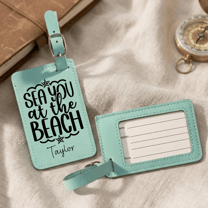 Two turquoise luggage tags with text on a beige fabric background