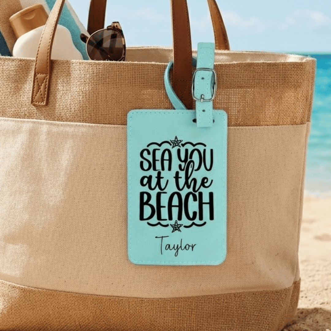 Beach bag with 'Sea you at the Beach' luggage tag on a beach background