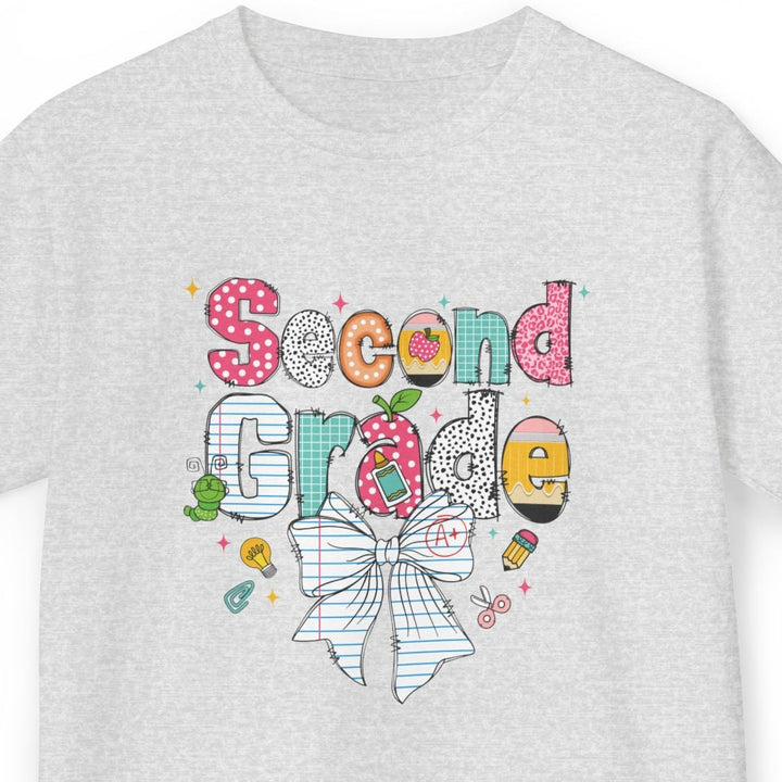 A light ash gray short-sleeve t-shirt with a colorful 'Second Grade' school graphic on the chest, featuring a striped bow, polka dots, and school-themed doodles, shown against a plain white background.