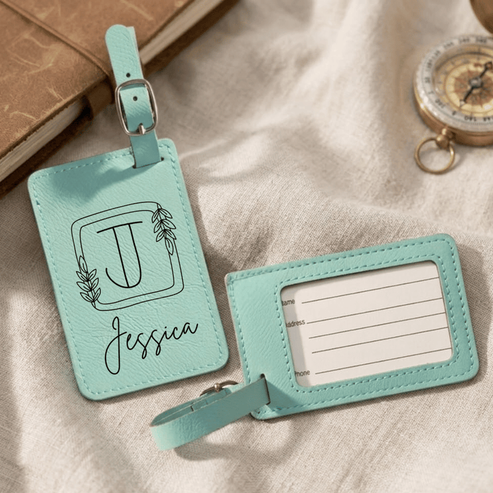 Two turquoise luggage tags with a name and design on a textured surface.