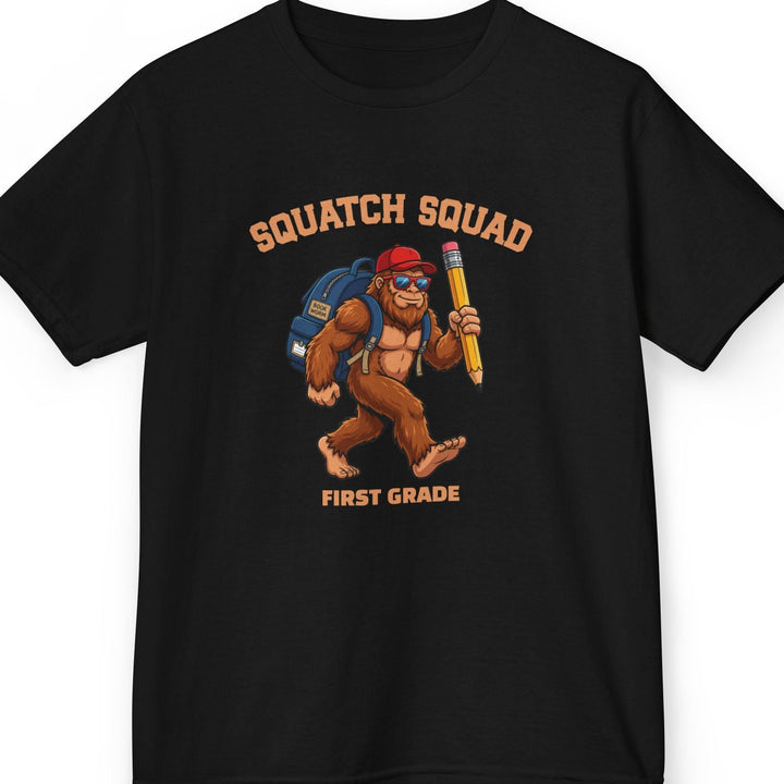 Black t-shirt with 'Squatch Squad' collegiate text in an arc on top of a bigfoot cartoon character wearing a blue backpack, red hat, and holding a giant pencil. Bottom line of text is personalizable. This one says 'first grade'