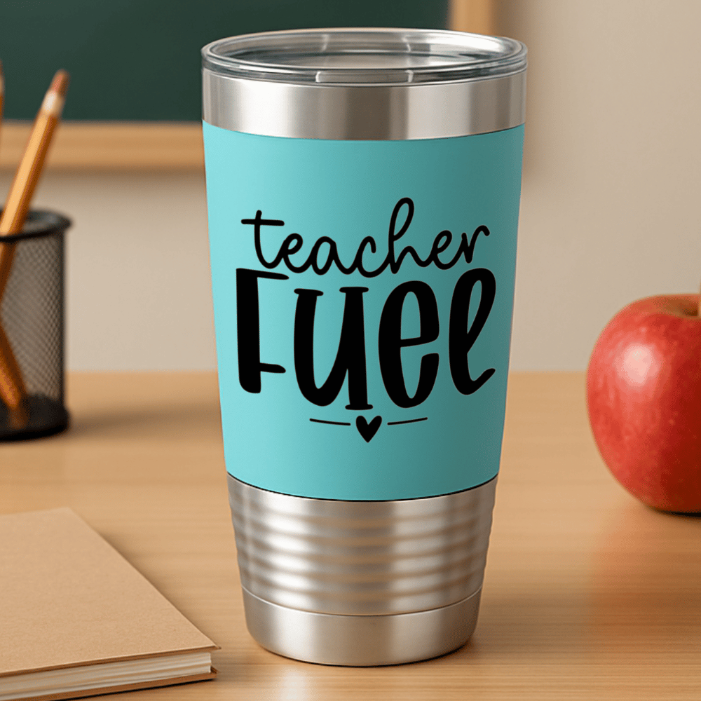 teal tumbler with 'teacher fuel' engraved in black sitting on a teacher desk with pencils and apple in background