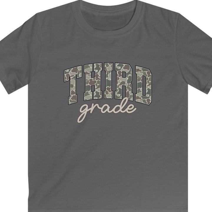 A dark gray short-sleeve t-shirt with a graphic on the chest reading 'THIRD grade'. The word 'THIRD' is filled with a green and brown camouflage pattern, while 'grade' is written below in a light beige cursive font.