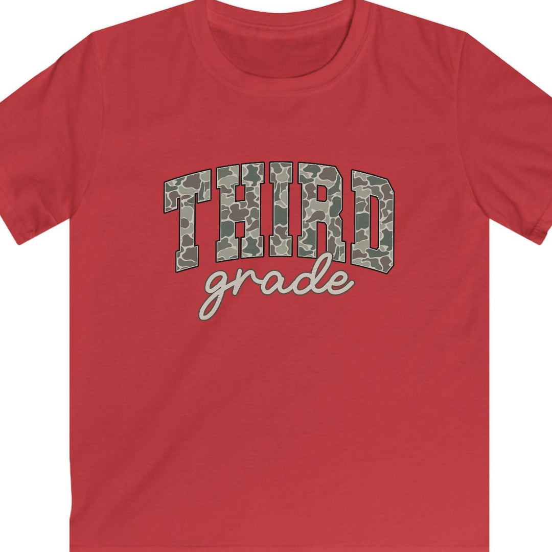A red short-sleeve t-shirt with 'THIRD grade' printed on the chest. The word 'THIRD' is in a green and gray camouflage pattern, while 'grade' is written below in a tan cursive font.