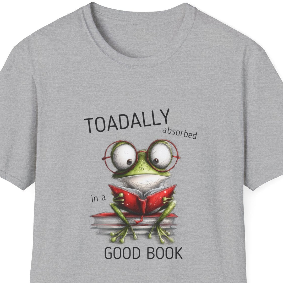 A light gray heather crewneck t-shirt featuring a cartoon graphic of a green frog wearing glasses and reading a red book, with the text 'TOADALLY absorbed in a' above and 'GOOD BOOK' below.