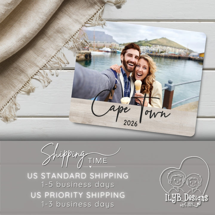 Photo board plaque with a photo of a couple in Cape Town, 2026, on a wooden surface with text about shipping times.