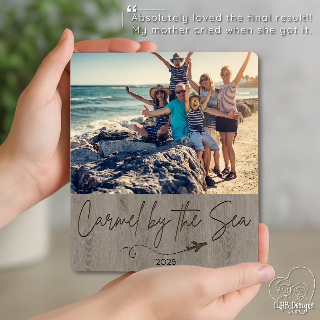 Hand holding a wooden photo plaque with a family photo and 'Carmel by the Sea 2025' text.