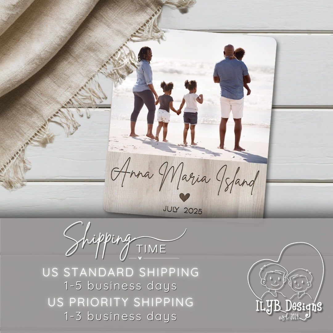 Photo board plaque with family photo and text 'Anna Maria Island, July 2025' on a wooden surface with a blanket.