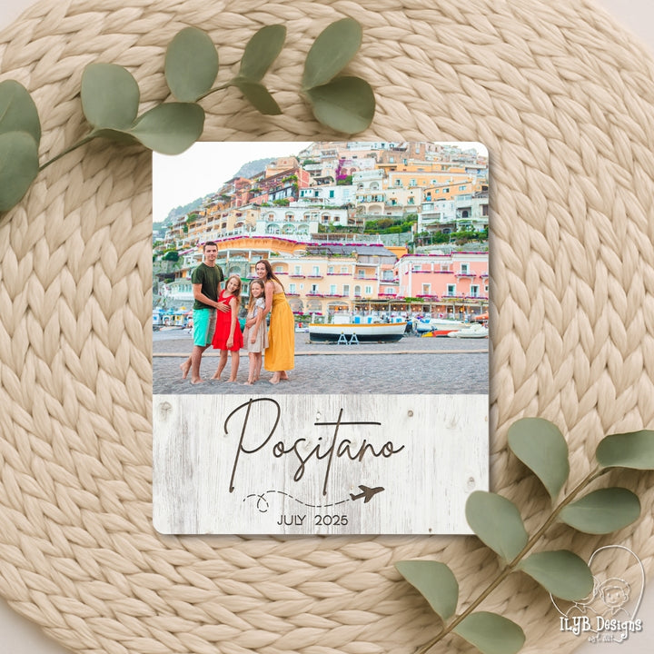 Photo plaque with a family photo and 'Positano' text on a woven surface with green leaves.