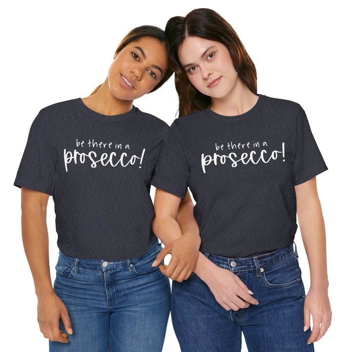 Two people wearing heather navy blue t-shirts with 'be there in a prosecco!' text on a white background