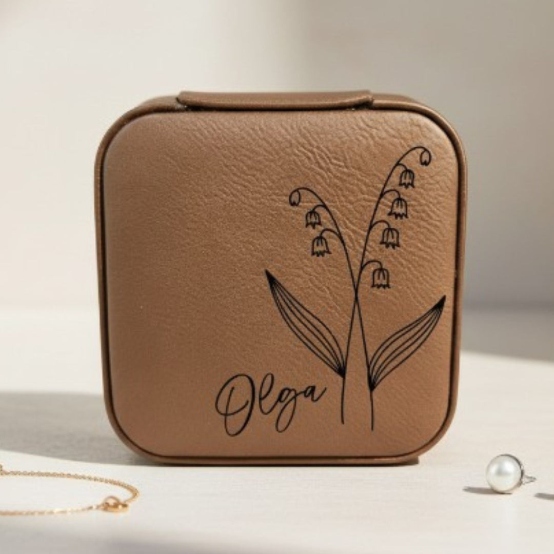 Brown leather jewelry case with floral design and 'Olga' engraving in black on a light background