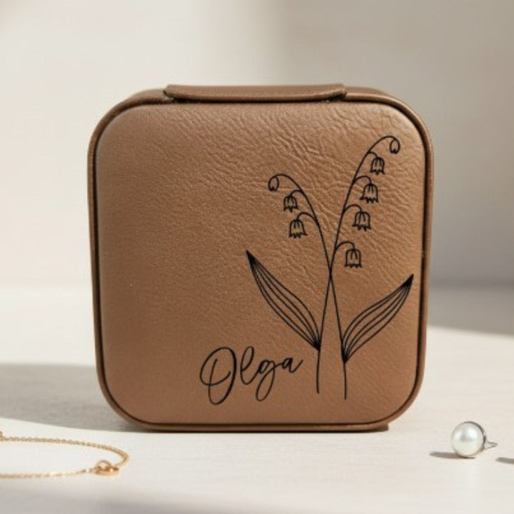 Brown leather jewelry case with floral design and 'Olga' engraving in black on a light background