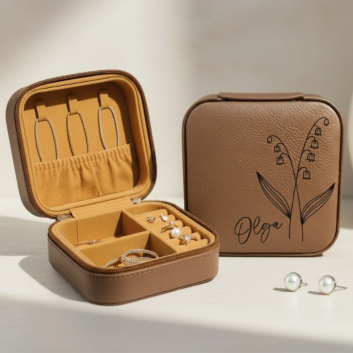 Brown jewelry case with 'Olga' and birth month flower engraving, open to reveal jewelry, on a light background.
