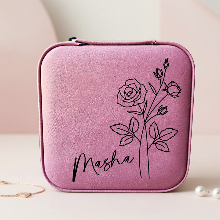 Pink jewelry case with a rose design and 'Masha' text engraved in black on a light background