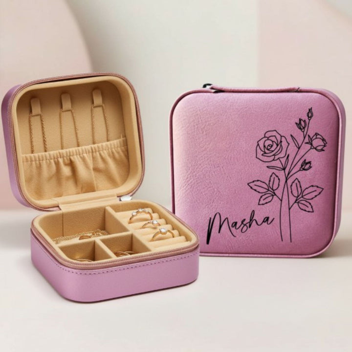 Pink jewelry case with 'Masha' name engraved in script font and rose design engraved in black sitting on a light background
