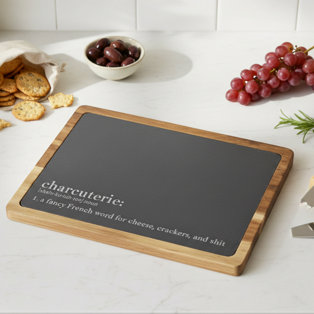 charcuterie board with funny 'charcuterie' definition on a kitchen counter with grapes and crackers.