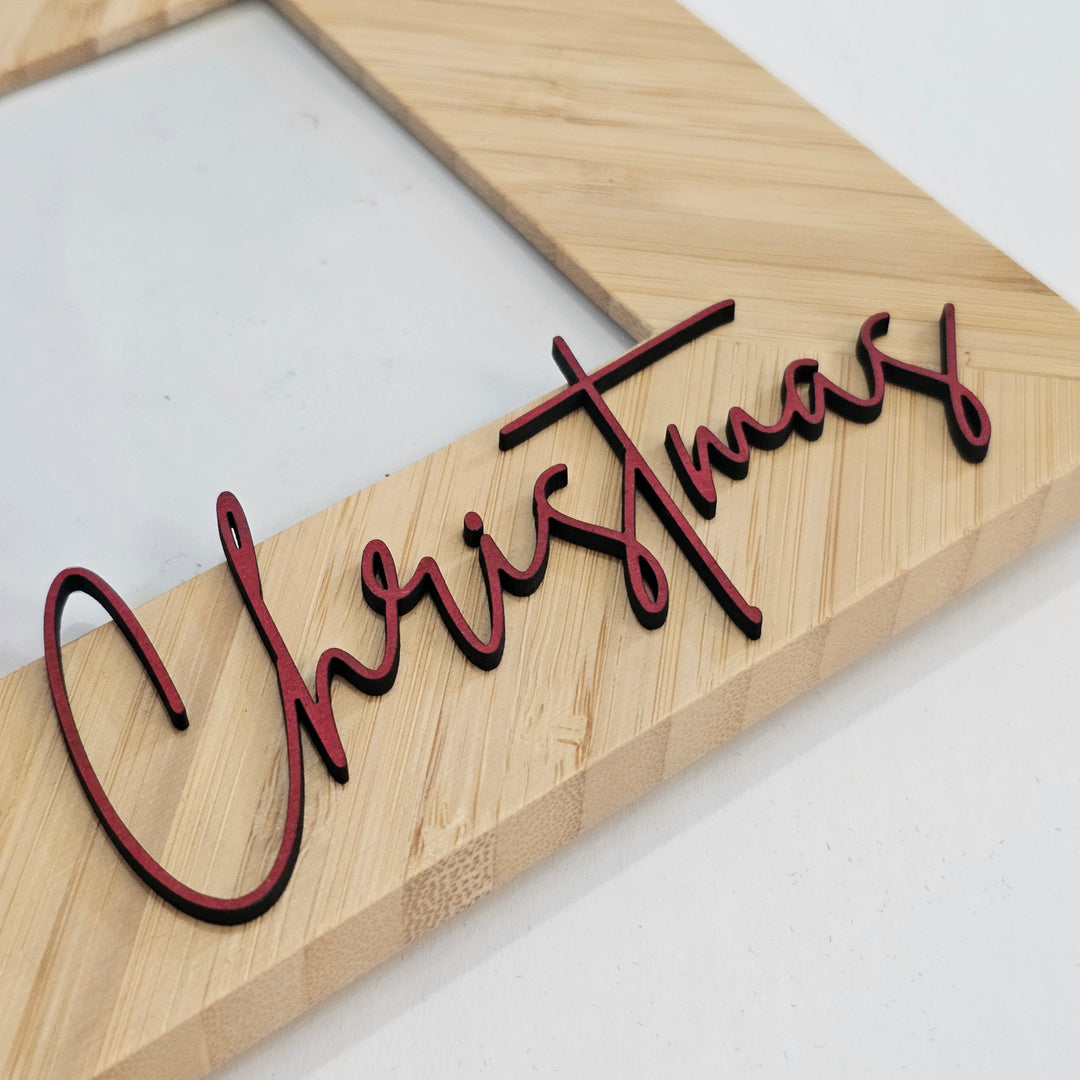 A close-up of a laser-cut wooden bamboo frame featuring the word &