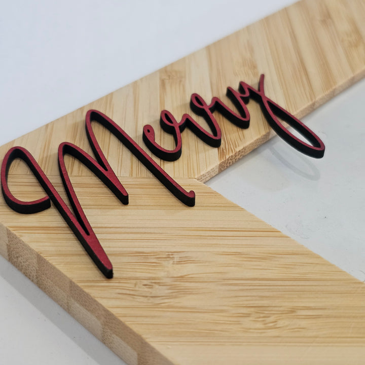 A close-up of a bamboo picture frame with a red laser-cut wood &