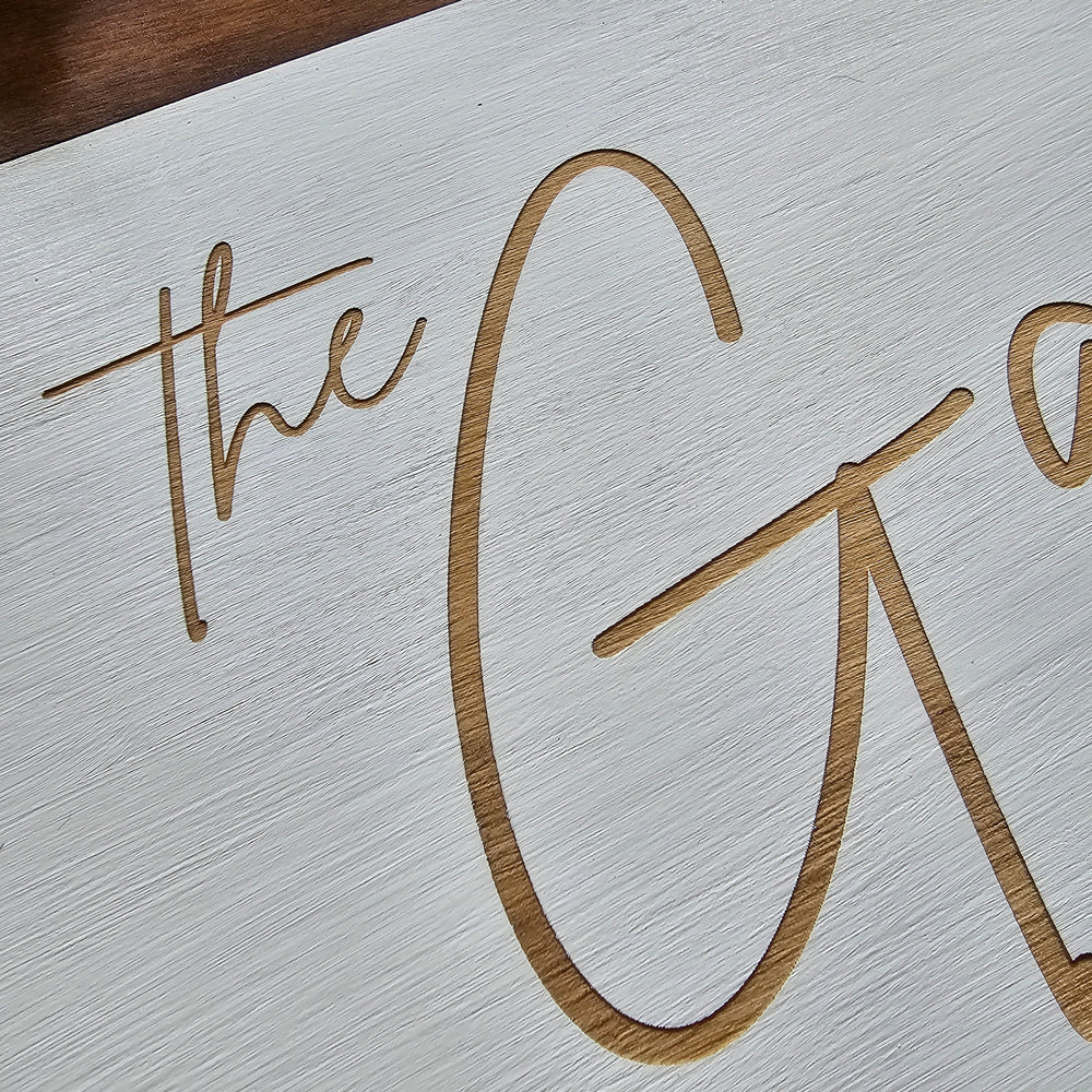 Close-up of engraved text on a textured white wood 
surface