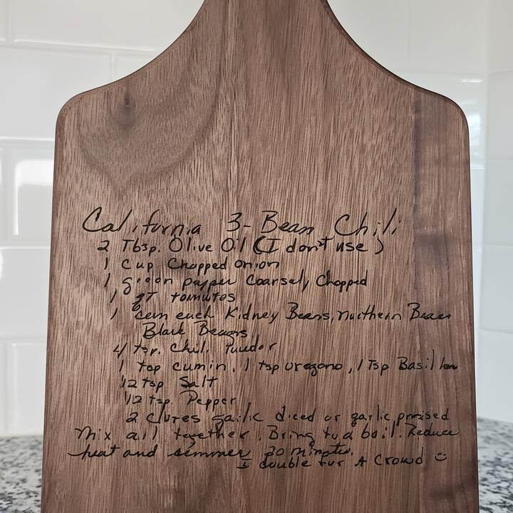 close up of wooden cutting board with handwritten recipe for California 3-Bean Chili.