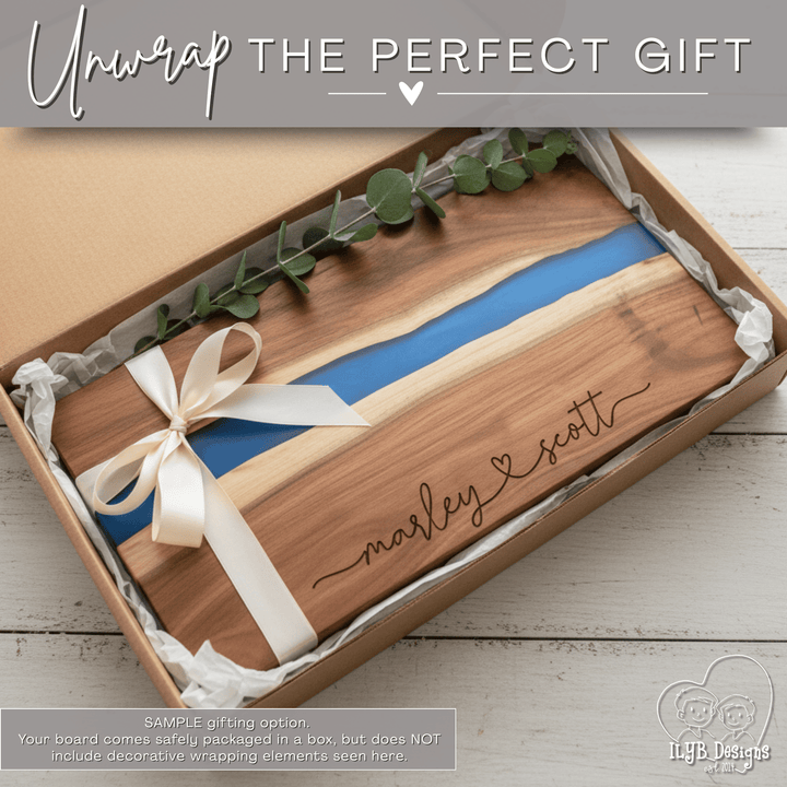 Wooden cutting board with blue resin design and 'marley & scott' engraving, wrapped in a box with a bow.
